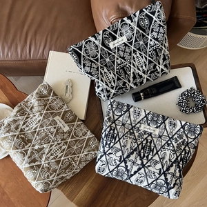 Detailed view of hand-embroidered cotton linen pouches with geometric ethnic patterns