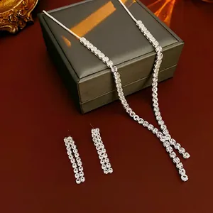 Luxurious silver tassel necklace and earrings set with zircons on red silk background