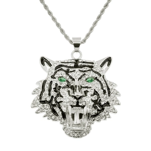Detail of silver tiger head pendant with green gem eyes and sparkling crystals