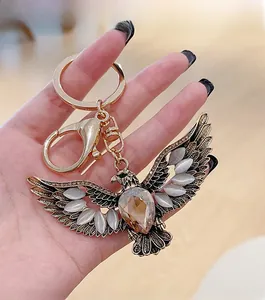 Detailed shot of eagle keychain with golden wings, cat's eye stones, and amber crystal
