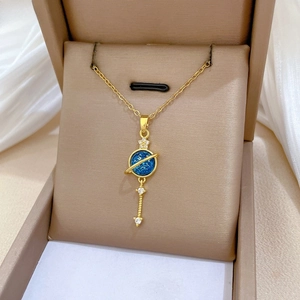 Detail of gold planet pendant with dark blue resin sphere and crystal accents on chain