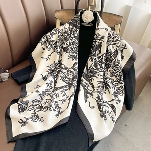 Dettaglio di elegante sciarpa di seta bianca con stampe floreali nere su una camicetta