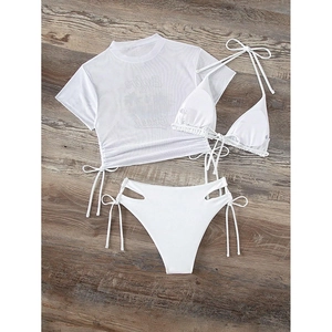Detailed flat lay of white three-piece bikini set with high-waisted bottoms and mesh cover-up