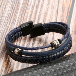 Macro detail of braided leather bracelet with silver metal beads and magnetic clasp