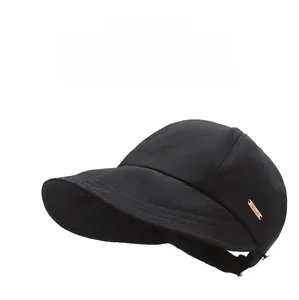 Vue détaillée de la casquette de soleil noire avec logo en métal or rose