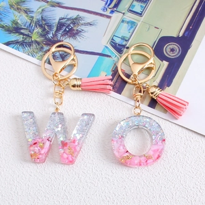 Resin letter W and O glitter keychains with pink tassels and gold lobster clasps