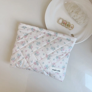 Detail of pink floral quilted cotton pouch featuring simple wish tag and soft texture