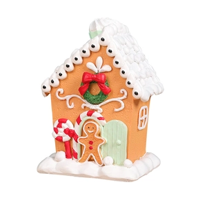 Gingerbread house Christmas ornament with red bows and snowy roof on white background