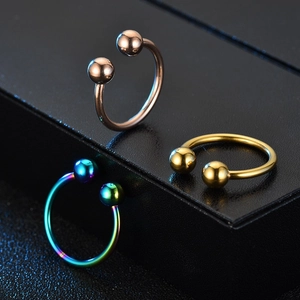 Detail view of horseshoe circular barbells in rose gold, gold, and rainbow finishes