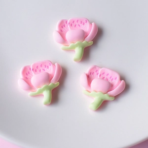 Three pink peach blossom resin charms for DIY hair accessories and car decor on white plate