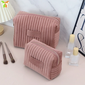 Detail of two-piece pink velvet cosmetic bags showing quilted texture and handle