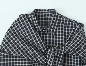 Detail of classic black and white plaid shirt showing collar and buttoned placket texture