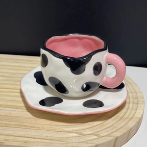 Macro shot of irregular handmade cow print ceramic cup and pink glazed handle