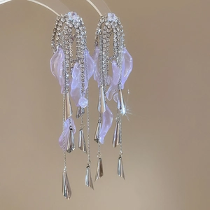 Detail of silver bow earrings with lavender leaves and sparkling rhinestone tassels