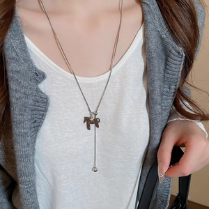 Close-up of a silver horse pendant necklace with gold star detail on a female model