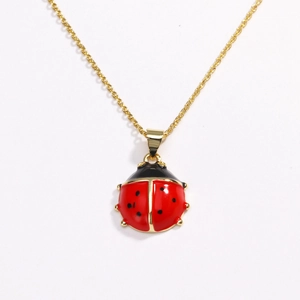 Charming red ladybug pendant necklace with gold chain on a clean white background