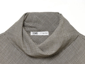 Detail of high collar and black and white houndstooth knit fabric texture on size S top