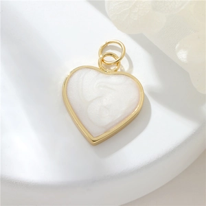 Elegant 14K gold plated white heart pendant with swirl enamel texture on a stone base