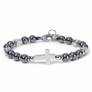 Detail view of dark grey beaded bracelet with silver cross pendant and lobster clasp