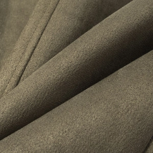 Close-up of olive green velvet blazer fabric showing soft folds and luxury texture
