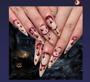 Detail of long stiletto Halloween press-on nails featuring realistic red blood drip designs