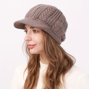 Detalle del tejido de ochos grueso en una gorra de punto marrón de invierno para mujer