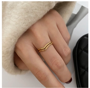 Close-up of a stylish double-layer V-shaped 18K gold ring worn by a model