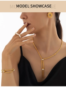 Détails de l'ensemble de bijoux dorés avec texture tressée et strass portés par modèle