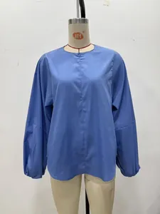 Détail de la blouse en popeline bleu clair montrant les manches ballon et la couture