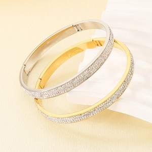 Vue détaillée de bracelets superposés en acier titane doré et argenté sertis de diamants