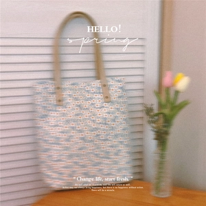Vue détaillée du sac cabas floral bleu en toile avec bandoulière en cuir et rivets