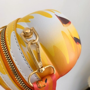 Detail view of round bag with orange gradient, gold metal hardware and Halloween strap