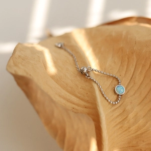 Macro detail of adjustable silver bead ring featuring a round opal stone with blue fire