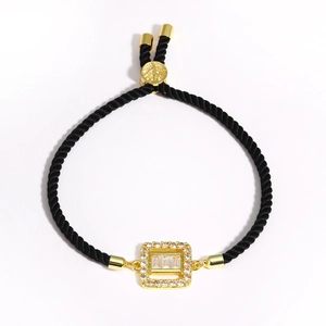 Black woven rope bracelet featuring a golden square frame with zircons and peace charm