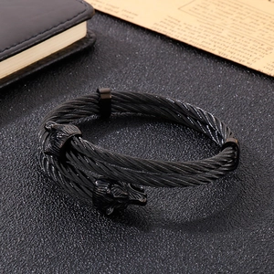 Detail of black stainless steel twisted wire cable bracelet with dual wolf head design