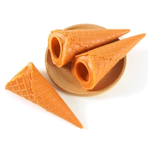 Detailaufnahme hellorangefarbener Waffeltüten-Modelle mit Gitterstruktur auf Holzplatte
