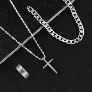 Close-up of silver cross pendant necklace, thick curb chain, and hollow ring set