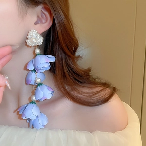 Orecchini a nappa con fiori viola e perle su modella, stile lungo e bohémien chic