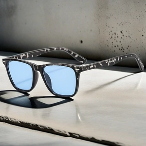Close-up of retro square sunglasses with floral texture frame and light blue lenses
