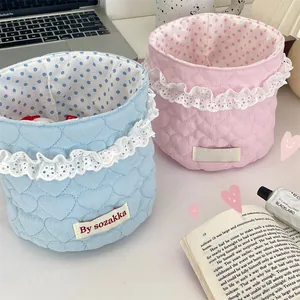 Detailed view of quilted fabric baskets with lace trim and heart pattern stitching