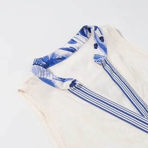 Detail of V-neck sleeveless top with blue floral print collar and striped trim