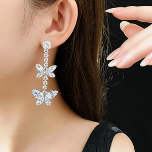 Gros plan de boucles d'oreilles papillon élégantes avec des zircons étincelants