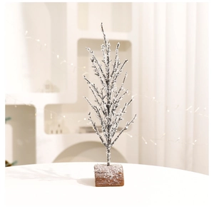 Detail of frosted pine needle branch with white crystals on a rustic wooden base