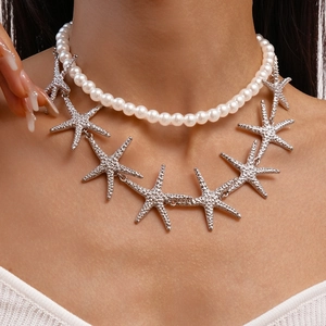 Close-up of double layer necklace featuring white pearls and silver starfish charms