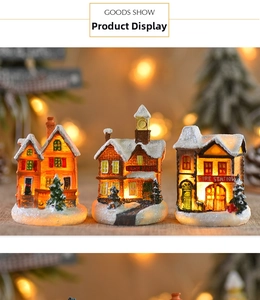 Detailed view of resin Christmas village houses with warm LED lights and snowy accents
