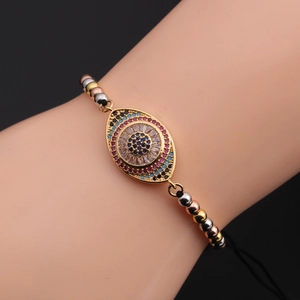 Macro detail of gold evil eye bracelet with colorful cubic zirconia and sliding chain