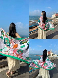 Detail of a thin travel shawl featuring elephant and palm tree prints by the beach