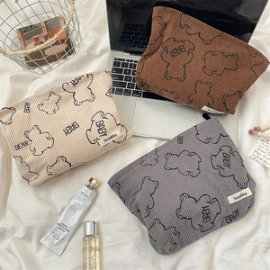 Detailed view of corduroy bear makeup bags in beige, brown and grey colors