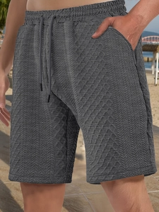 Detail of dark gray leisure shorts with jacquard texture and side zipper pocket