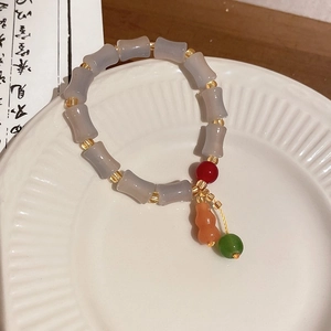 Détail du bracelet en perles de bambou style néo-chinois avec pendentif en gourde